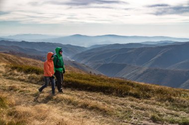 Güz. Çift backpackers sonbahar dağlarda yolda hiking.