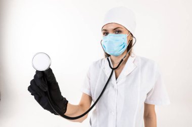 Kadın doktor elinde bir fonendoskop tutuyor..