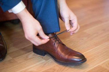 Bir adam onun foorwear ayakkabı bağcığı bağlıyor