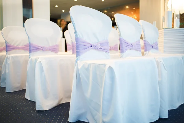 Cadeiras de casamento branco decorado com arcos roxos — Fotografia de Stock