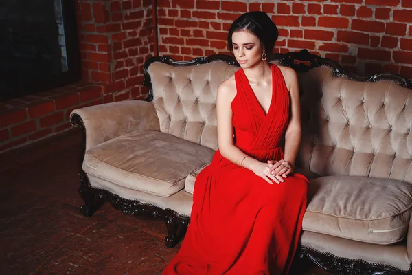 Красивая дама в красном платье с вечерним макияжем — стоковое фото