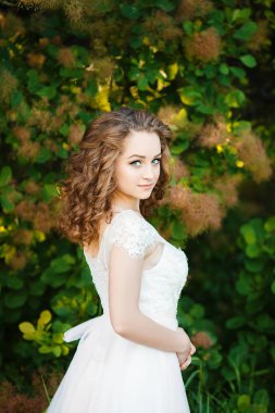 kıvırcık saçlı kız beyaz elbisesi giymiş