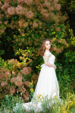 kıvırcık saçlı kız beyaz elbisesi giymiş