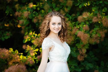 kıvırcık saçlı kız beyaz elbisesi giymiş