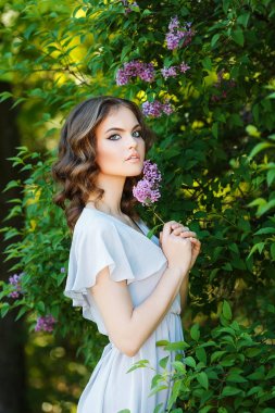 kıvırcık saçlı kız beyaz elbisesi giymiş