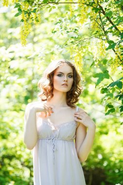 kıvırcık saçlı kız beyaz elbisesi giymiş