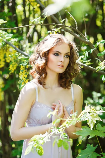 Curly haired girl dressed in white gown — Stock Photo, Image