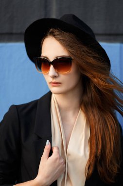 Güzel kızıl saçlı model siyah şapka ve güneş gözlüğü