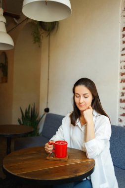 Kırmızı fincan kahve güzel bir gülümseyen kız elinde