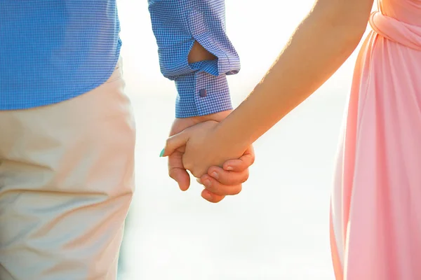 Pareja cariñosa cogida de la mano en el mar — Foto de Stock