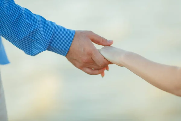 Pareja cariñosa cogida de la mano en el mar — Foto de Stock