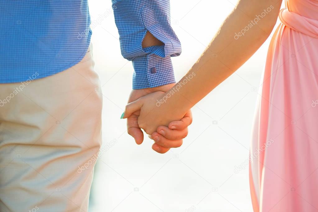 Loving couple holding hands at sea