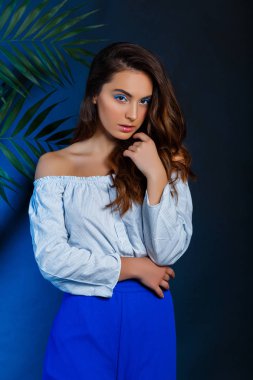 Stüdyo portre genç seksi model yeşil yaprakları ile