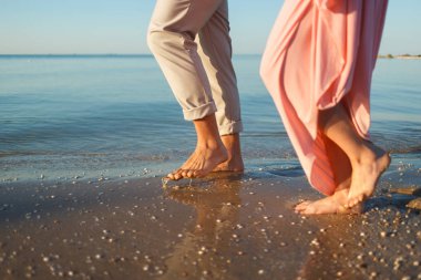 Kumsalda yürüyen çift.