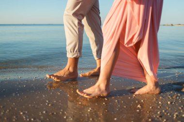 Kumsalda yürüyen çift.