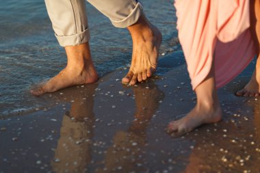 Kumsalda yürüyen çift.