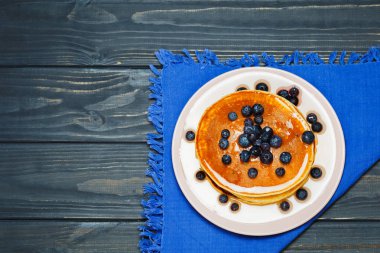 Bal ve mavi peçeteye yaban mersini ile Pancakes