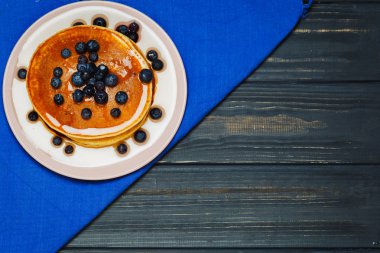 Bal ve mavi peçeteye yaban mersini ile Pancakes