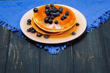 Bal ve mavi peçeteye yaban mersini ile Pancakes