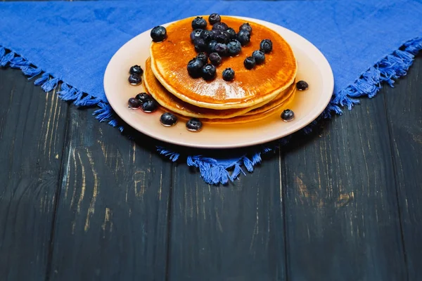 Panquecas com mel e mirtilos em um guardanapo azul — Fotografia de Stock