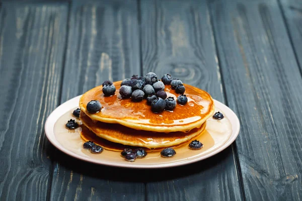 Pfannkuchen mit Honig und Blaubeeren auf Holztisch — Stockfoto