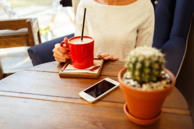 Bir kafede akıllı telefondan mesaj yazan bir kadın