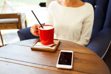 Bir kafede akıllı telefondan mesaj yazan bir kadın