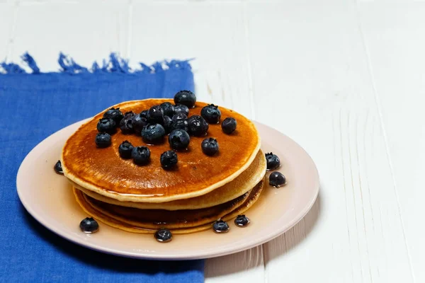 Panqueques con miel y arándanos en una servilleta azul — Foto de Stock