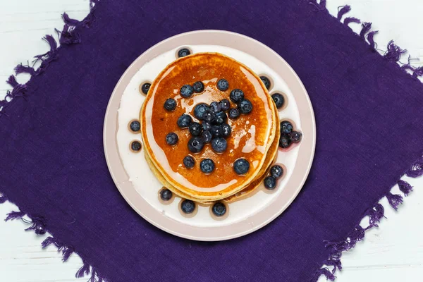 Weihnachten Pfannkuchen mit Honig und Blaubeeren auf einer violetten Serviette — Stockfoto