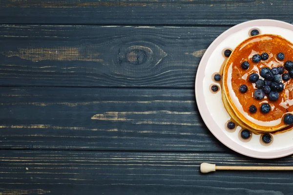 Pfannkuchen mit Honig und Blaubeeren auf Holztisch — Stockfoto