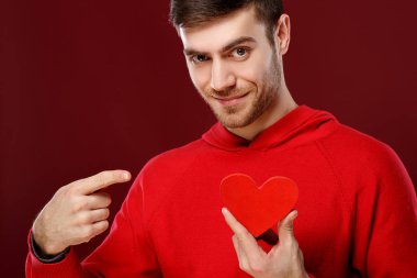 Sevgililer günü onun elinde kırmızı bir kalp ile yakışıklı delikanlı