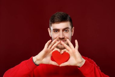 Sevgililer günü onun elinde kırmızı bir kalp ile yakışıklı delikanlı