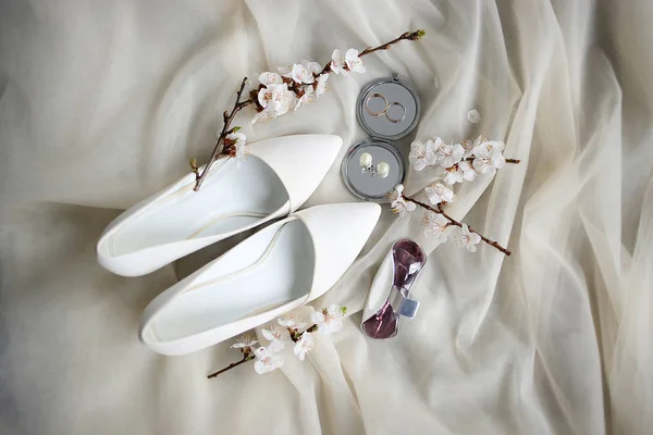 Alianças de casamento e sapatos na manhã de casamento da noiva — Fotografia de Stock