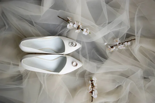 Alianças de casamento e sapatos na manhã de casamento da noiva — Fotografia de Stock