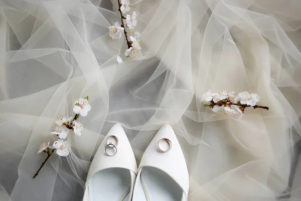 Alianças de casamento e sapatos na manhã de casamento da noiva — Fotografia de Stock