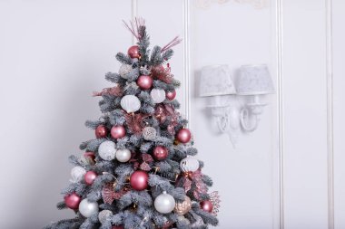 Christmas tree decorated with beautiful toys on a studio background. Place for text.
