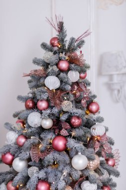 Christmas tree decorated with beautiful toys on a studio background. Place for text.