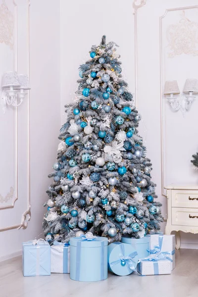 Mooie kerstboom versierd met speelgoed en geschenkdozen — Stockfoto