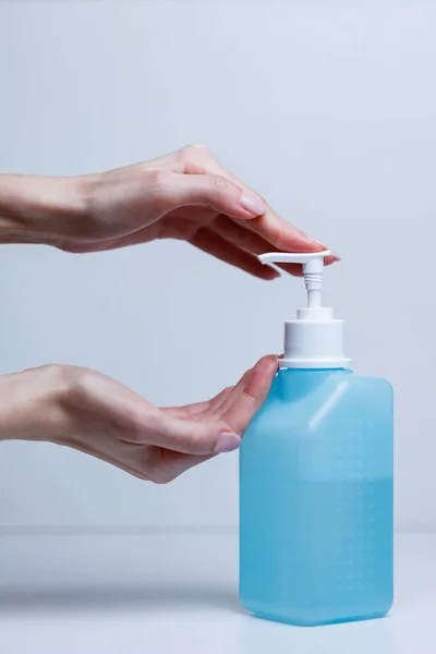 Hand sanitizer alcohol gel rub clean hands hygiene prevention of coronavirus virus outbreak. Woman using bottle of antibacterial sanitiser soap.