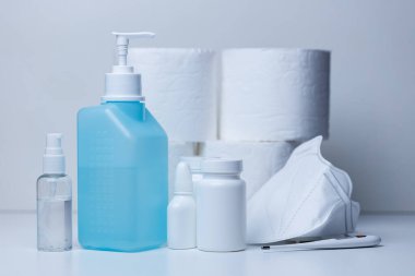 Corona virüsü salgını için raflardaki hastane malzemelerinde el dezenfektanı şişesi ve yüz maskeleri var. Coronavirus COVID-19 el hijyeni önleme.