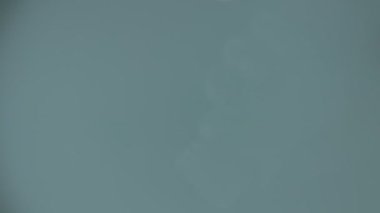 turuncu haplar mavi arka plandaki bir kavanozdan dökülür..