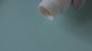 turuncu haplar mavi arka plandaki bir kavanozdan dökülür..