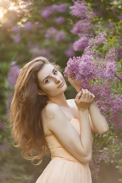 Bahar leylak bahçesinde eski moda elbiseli güzel bir kız..