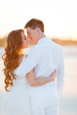 Damat gün batımında çölde gelini kucaklıyor.