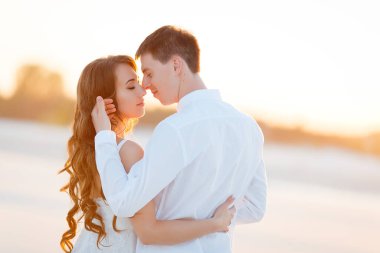 Damat gün batımında çölde gelini kucaklıyor.