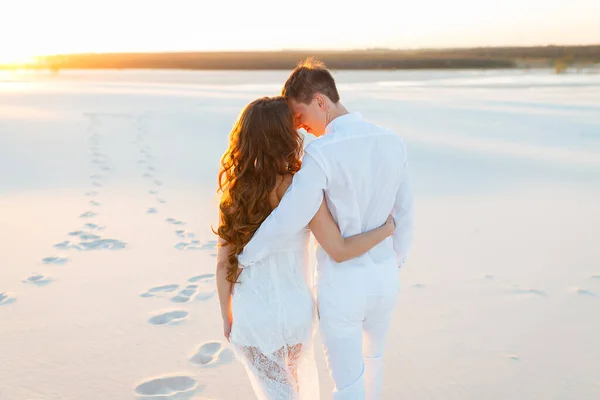 Sposo abbracciare sposa nel deserto al tramonto — Foto Stock