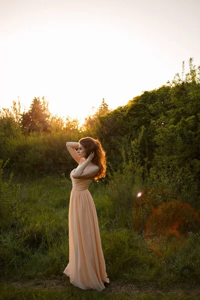 Retrato de uma menina bonita na natureza ao pôr do sol — Fotografia de Stock