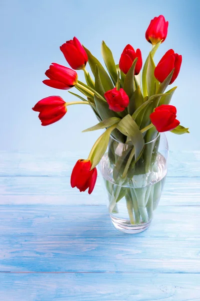 Красные тюльпаны на деревянном столе — стоковое фото