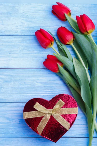 Boeket van rode tulpen en geschenkdoos — Stockfoto