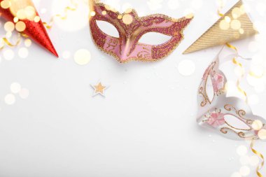 Beyaz arkaplandaki karnaval maskeleri ve konfetileri kopyalama alanı düzleşmişti